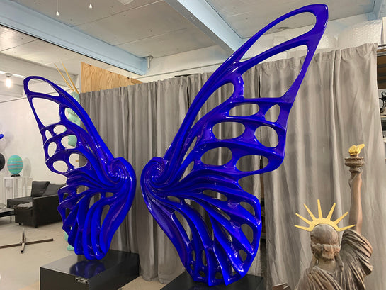 Name: Dream Machine – Blue Medium: Painted Fiberglass Sculpture with stainless steel Base. Size: 13’ x 4’ x 9’ ( Wings + Base). Signed: Hand-Signed. Edition: 1 of 6 Variations. Year: 2019