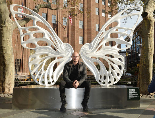 Name: Dream Machine I 
 Medium: Painted 
Fiberglass Sculpture with stainless structure and Base.
 Size: 13’ x 4’ x 9’5 ( Wings + Base).
 Year: 2017