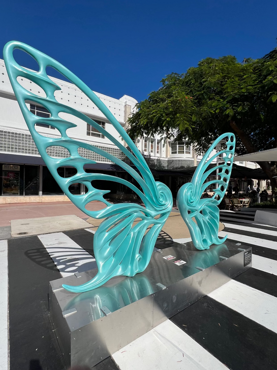 Name: Dream Machine II
 Medium: Painted 
Fiberglass Sculpture with stainless structure and Base.
 Size: 13’ x 4’ x 9’5 ( Wings + Base).
 Year: 2019